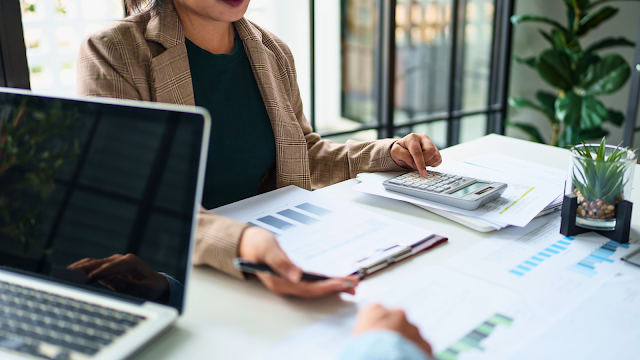 Profissionais em reunião de trabalho analisam relatórios e discutem estratégias de comunicação interna para melhorar a produtividade e alinhar equipas.