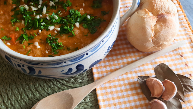 Tigela tradicional de açorda de frango decorada com salsa fresca, acompanhada de pão, alho e louro — prato típico português para celebrar o Dia Nacional da Gastronomia.