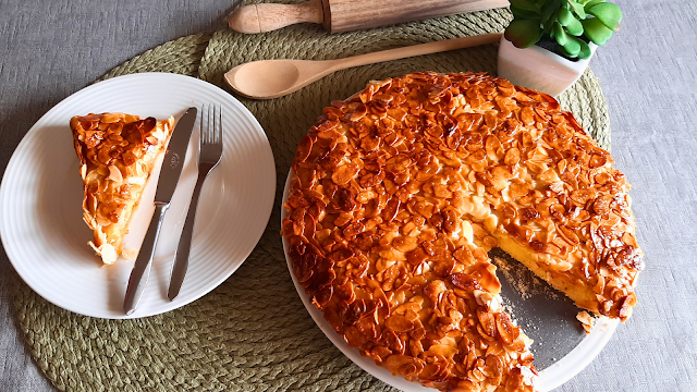 Deliciosa tarte de amêndoa caseira com cobertura dourada e crocante, servida em prato branco, pronta para ser saboreada.