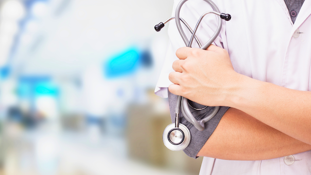 Médico de família com bata branca a segurar estetoscópio, símbolo de confiança e cuidados de saúde primários.