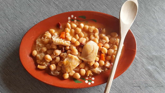 Prato de barro, com uma dose de calhos tipicamente portugueses, ao lado uma colher de pau