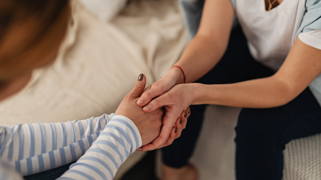 Duas pessoas a segurar nas mãos, oferecendo apoio emocional durante o fim de uma relação
