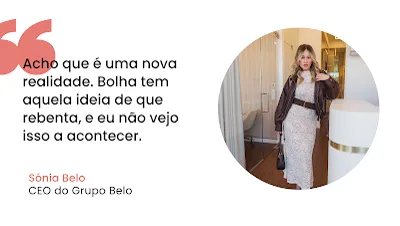 Imagem com fundo branco dividida em duas partes. Do lado esquerdo, destaca-se um símbolo de aspas cor-de-rosa seguido do texto em letras pretas: "Acho que é uma nova realidade. Bolha tem aquela ideia de que rebenta, e eu não vejo isso a acontecer." Abaixo da citação, o nome "Sónia Belo" está escrito a cor-de-rosa e o cargo "CEO do Grupo Belo" em preto. Do lado direito, uma moldura circular exibe a fotografia de uma mulher loira, com um vestido longo de renda clara, cinto largo, casaco de pele castanho e uma mala na mão, posando num escritório moderno com detalhes em madeira.