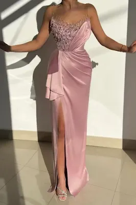 Vestido Longo Rosa de Festa com Brilho e Fenda Mulher a vestir um vestido longo de festa rosa com corpete brilhante, drapeado lateral e uma fenda profunda na perna.