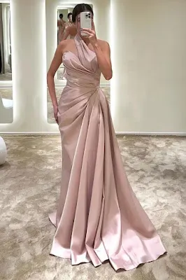 Vestido Longo Rosa de Festa com Drapeado e Cauda Mulher a tirar uma selfie ao espelho num provador, vestindo um vestido longo rosa acetinado de ombro só, corpete drapeado e uma cauda elegante.